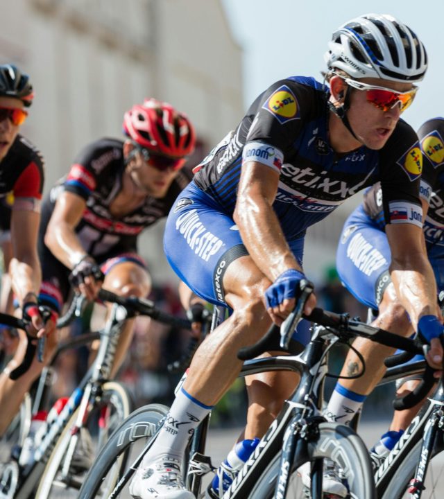 Competitive cyclists in a high-speed race, showcasing athleticism and teamwork.