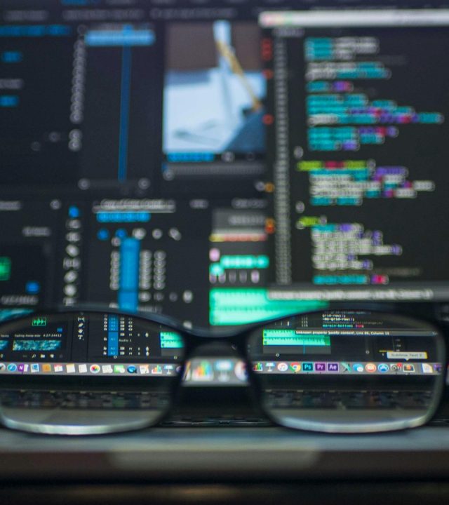 Eyeglasses reflecting computer code on a monitor, ideal for technology and programming themes.